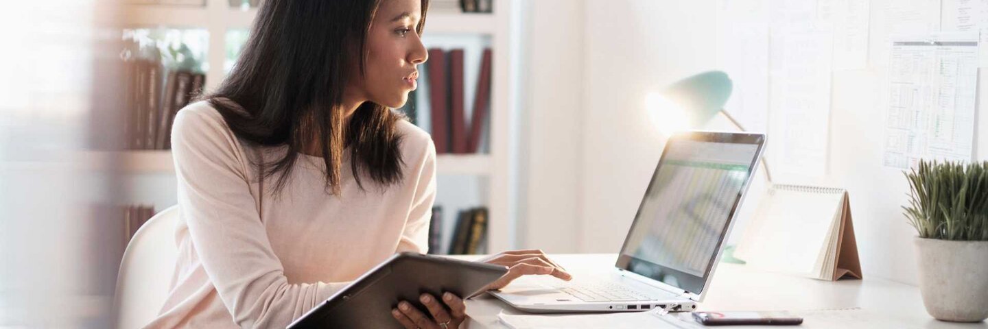 Woman looking up information on laptop at home.