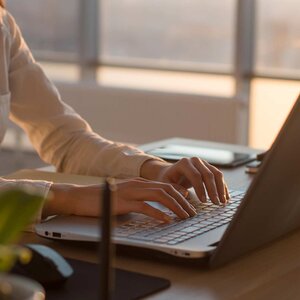 female hands typing on a laptop